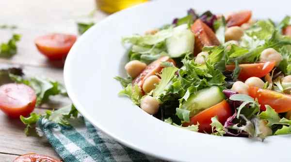 1766585199-healthy-chickpea-salad-with-tomatolettuce-cucumber-wooden-table