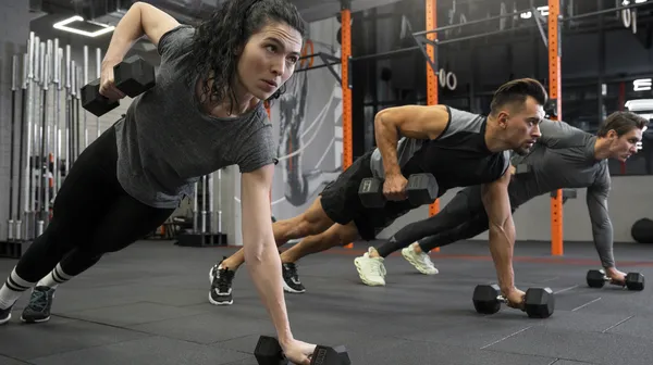 1765820175-people-working-out-indoors-together-with-dumbbells