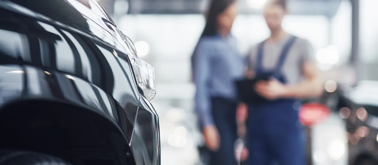 1769088398-beautiful-young-woman-is-talking-handsome-car-mechanic-while-repair-car-dealership