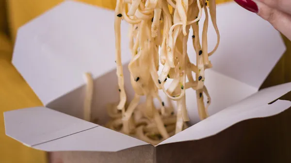 1770394184-woman-holding-noodles-chopsticks