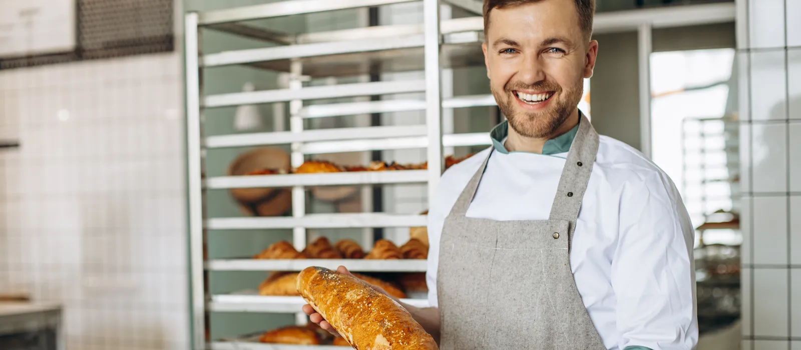 Man baker with fresh bread baker house